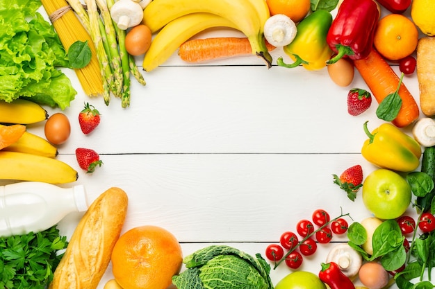 Vegetables, fruits assortment frame on white wooden background.
vegetarian healthy food concept. food and grocery shopping. free
space.