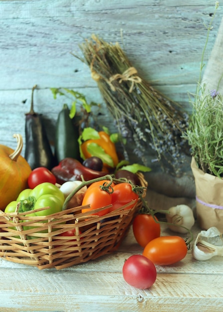 Vegetables and fruits in a basket spicy herbs on a wooden table autumn harvest concept