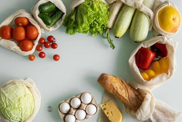 Foto verdure frutta uova in sacchetti riutilizzabili di cotone ecologico sul tavolo concetto di acquisto senza rifiuti senza plastica