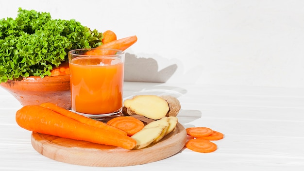 Photo vegetables and greenery with juice on table