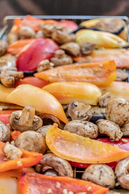 Vegetables on the grill close-up. Eggplants, peppers, mushrooms and garlic are roasted over charcoal. Vegetarian grill.