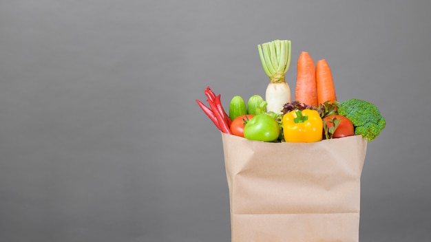 Vegetables in grocery bag on studio grey
