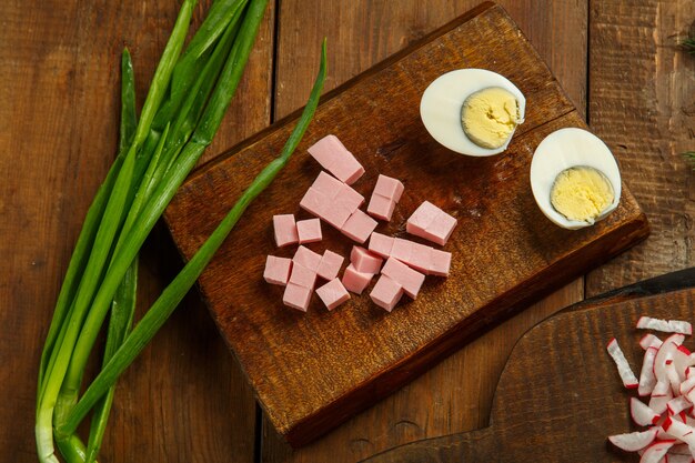 Vegetables and a knife on wooden planks on the table