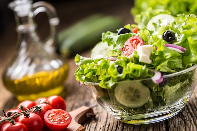 Vegetables lettuce salad with tomatoes onion cheese and olives.