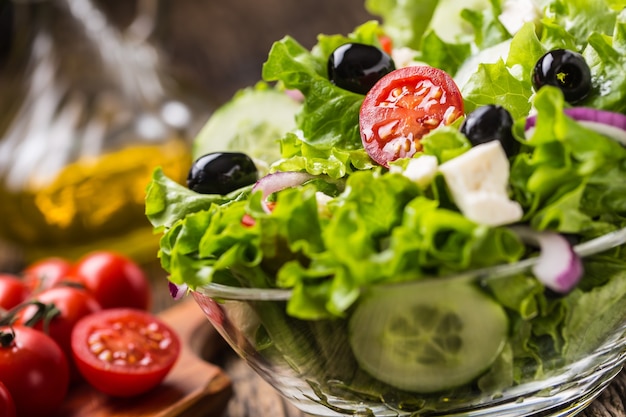 Insalata di lattuga con pomodori cipolla formaggio e olive.