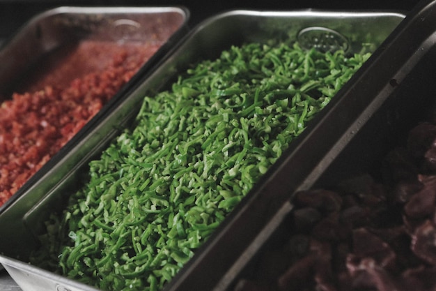 Vegetables and meat in the steel pots.