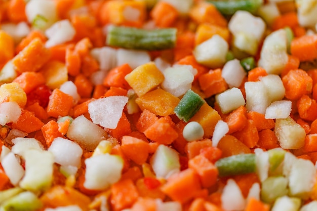 Vegetables mixture of chopped frozen vegetable string beans carrots pumpkin green peas closeup selective focus