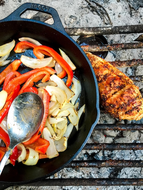 Foto verdure in padella con carne di pollo sulla griglia da barbecue