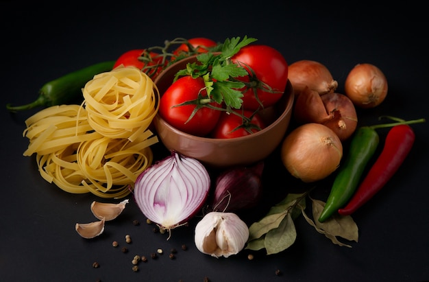 Vegetables and pasta on a black surface