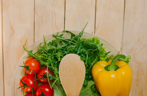 Photo the vegetables on the plate with the wooden spoon