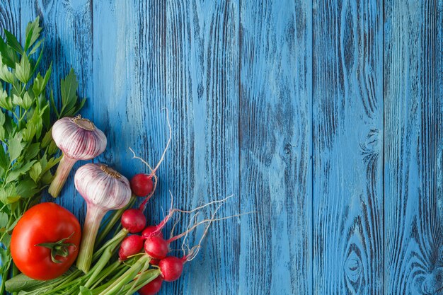 Vegetables set with garlic, tomatoes and radish on wooden surface