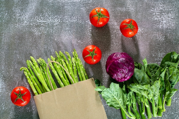 野菜と買い物袋黒の背景に紙袋に入った野菜とシリアル