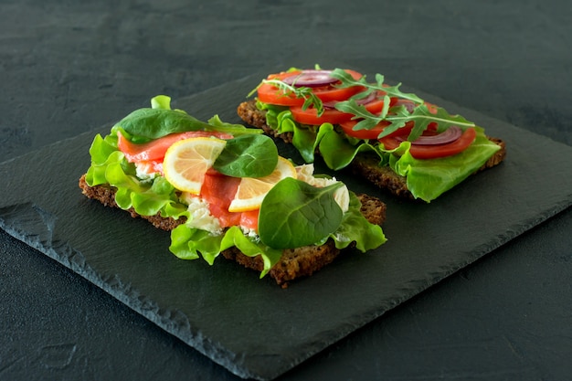 Vegetables and smoked salmon open sandwiches with cottage cheese, lattice, tomatoes and lemon 