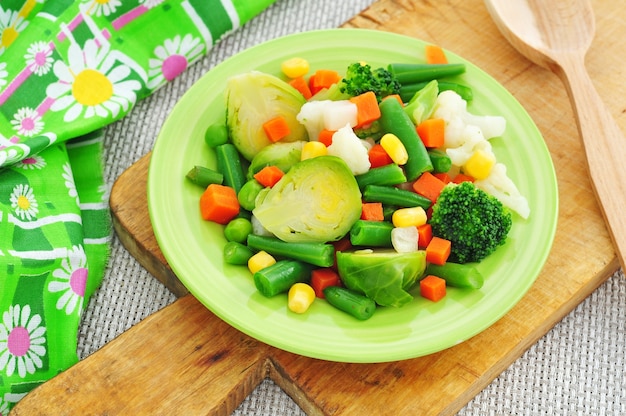 Vegetables stew in green plate on cutting board