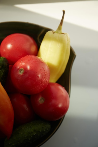Овощи, помидоры, лук и перец в зеленой миске ручной работы