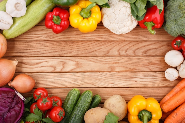 Vegetables on wood background with space for text.