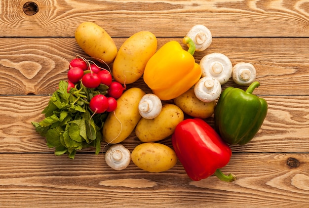 Vegetables on a wooden background. Potatos, Mushrooms, Peppers, Radish