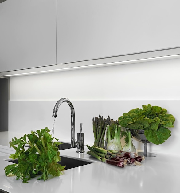 vegetables on the worktop near to sink in a modern kitchen