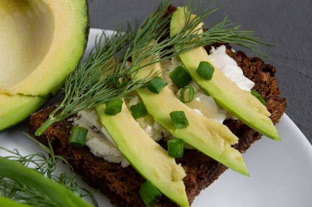 Vegetarain sandwich with cream cheese and avocado slices with dill and green onion