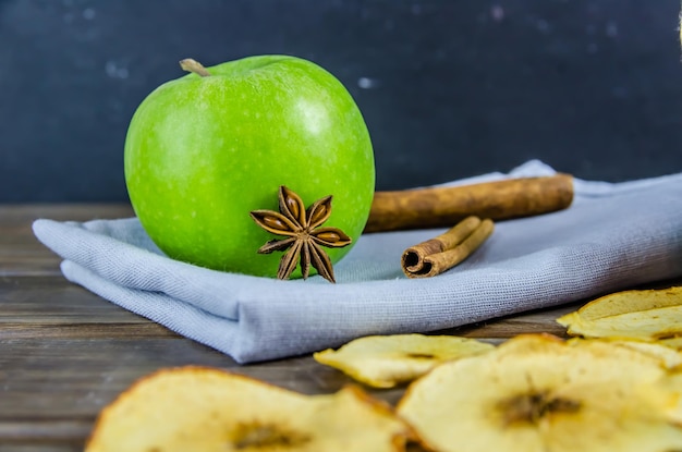 Vegetarian apple chips with cinnamon and badyan on a brown background