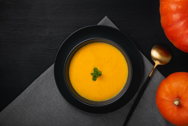 Vegetarian autumn pumpkin cream soup with seeds Top view with copy space