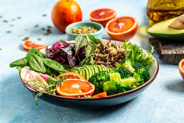 Vegetarian Buddha bowl with fruit and vegetable on a blue background, Healthy food concept. Vegan salad.