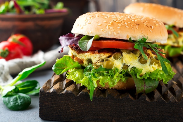 Vegetarian burger with scrambled eggs and peas