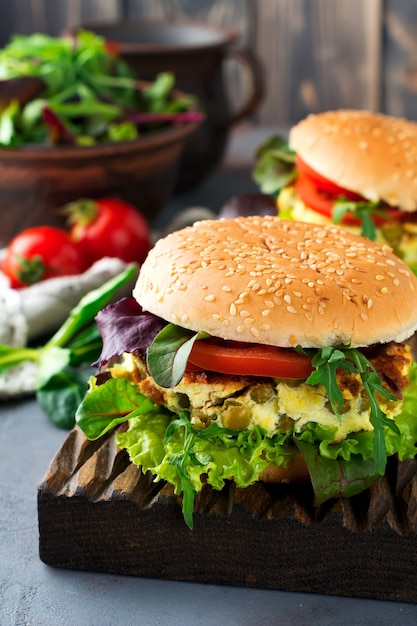 Vegetarian burger with scrambled eggs and peas