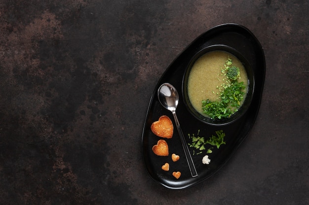 Vegetarian cauliflower and broccoli cream-soup with seeds heart shape crackers 