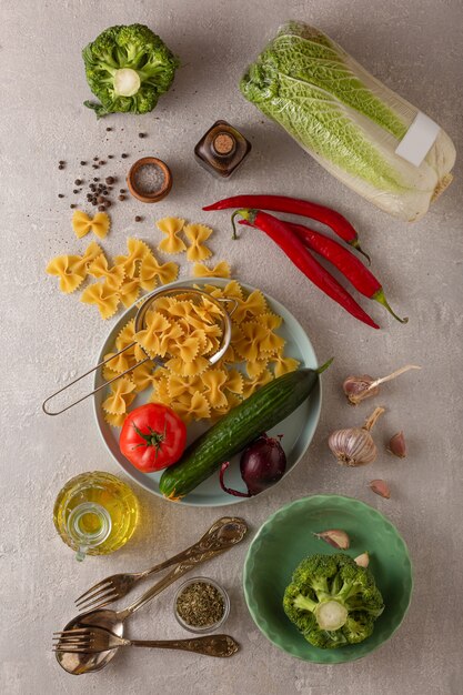 Vegetarian cooking pasta with vegetables and raw ingredients