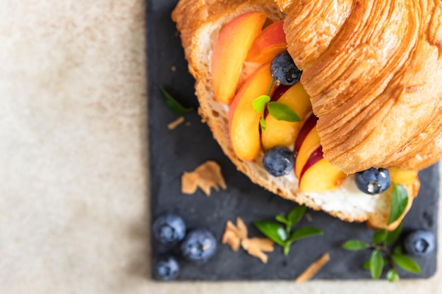 Vegetarian croissant sandwiches with nectarine soft or cream cheese blueberries and honey