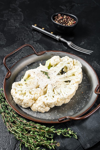 Vegetarian cuisine cooking of cauliflower steak Black background Top view