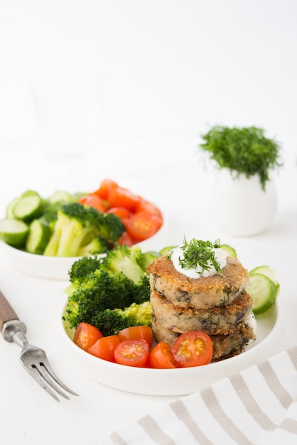 Vegetarian dish of potato patties with herbs and vegetables in a plate