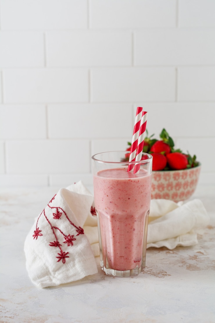 Photo vegetarian healthy smoothie from strawberry with berries on gray or white concrete background. selective focus. space for text.