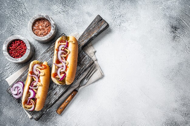 Vegetarian hot dog with with toppings and meatless sausage. White background. Top view. Copy space.