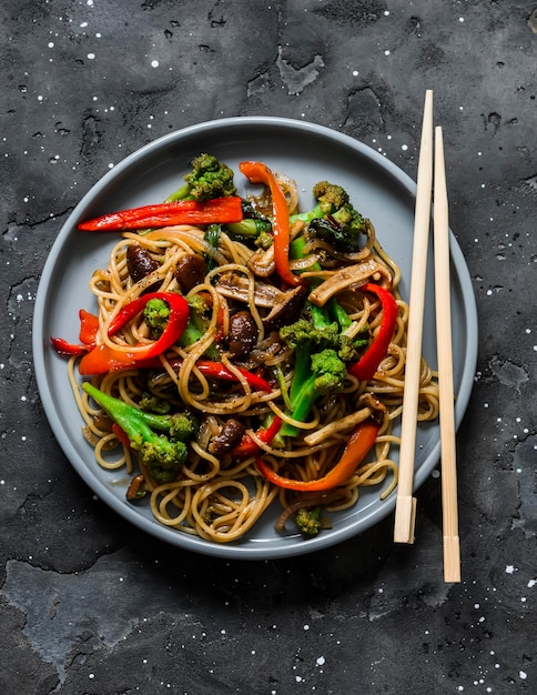 Vegetarian lunch noodles with vegetable stir fry teriyaki sauce\
on a dark background top view asian style food