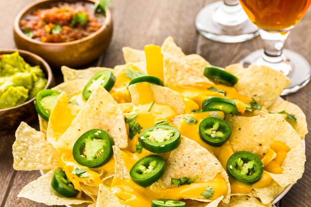 Photo vegetarian nachos with tortilla chips and fresh jalapeno peppers.