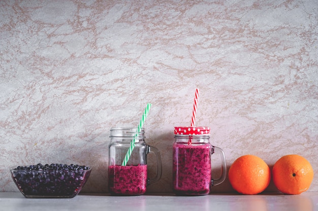 Vegetarian organic healthy berry drinks on background. Clean vegan food, eat right and drinking blueberry smoothie for diet