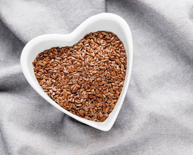 Photo vegetarian organic nutrition flax seeds in bowl on textile background
