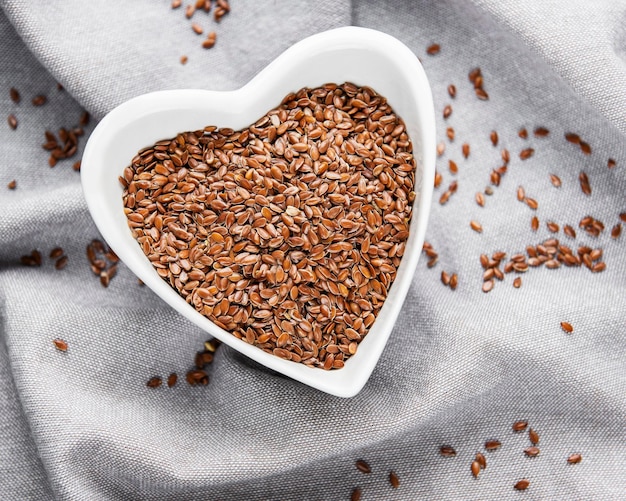 Vegetarian organic nutrition flax seeds in bowl on textile background