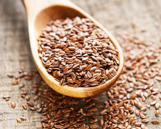 Vegetarian organic nutrition flax seeds in spoon on vintage wooden background