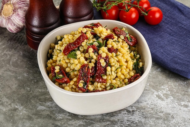 Vegetarian Pasta ptitim with vegetables and basil