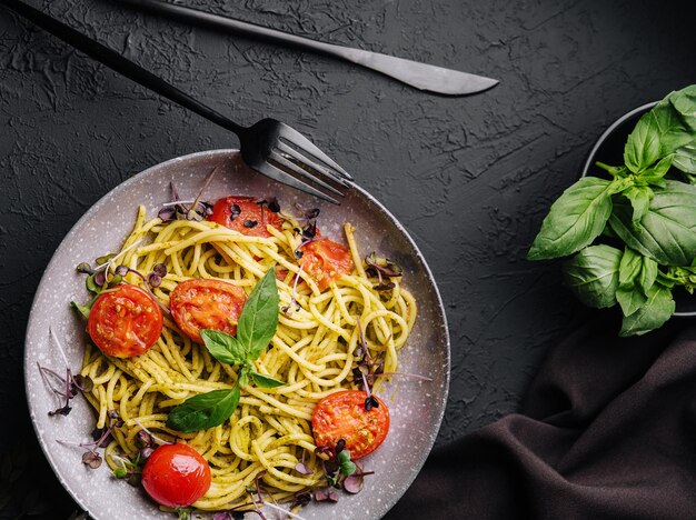 Vegetarian pasta spaghetti with basil pesto and cherry tomatoes