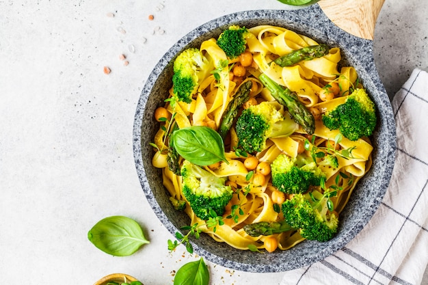 Vegetarian pasta with broccoli, asparagus and chickpeas in pan