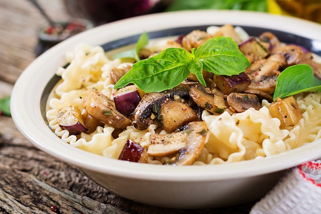 Vegetarian pasta with mushrooms and aubergines, eggplants. Italian food. Vegan meal.