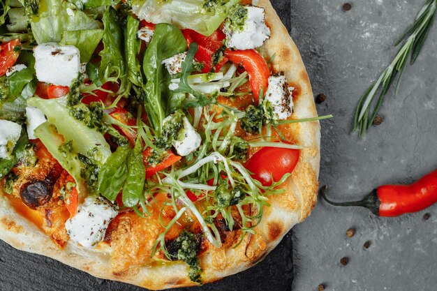 Vegetarian pizza with cheese tomatoes and greens