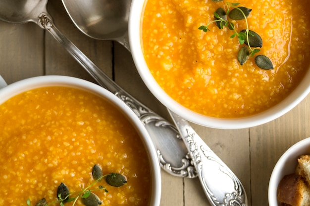 Vegetarian pumpkin soup on a wooden table.