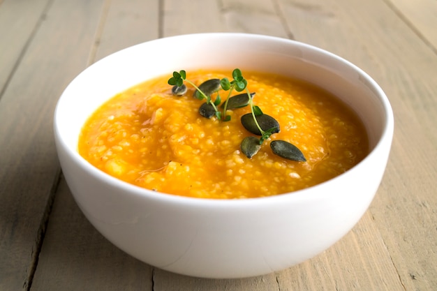 Vegetarian pumpkin soup on a wooden table.