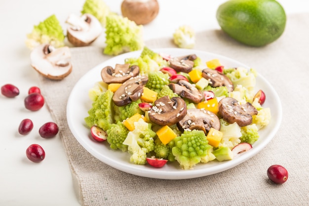 Vegetarian salad from romanesco cabbage, champignons, cranberry, avocado and pumpkin. side view