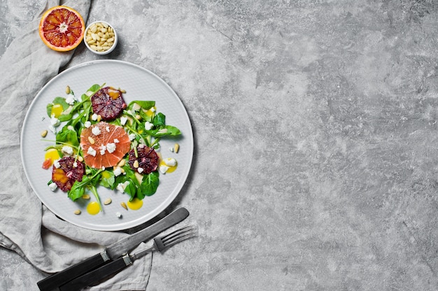 Vegetarian salad with arugula, grapefruit, red oranges, nuts and tofu cheese.